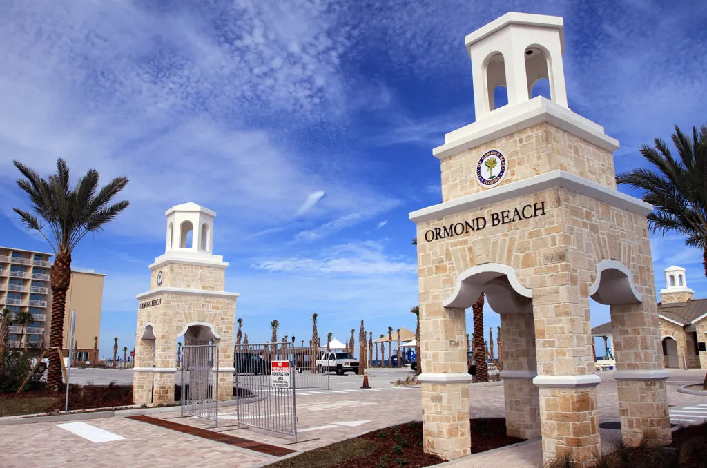 Ormond Beach entrance towers and palm trees beneath a blue sky